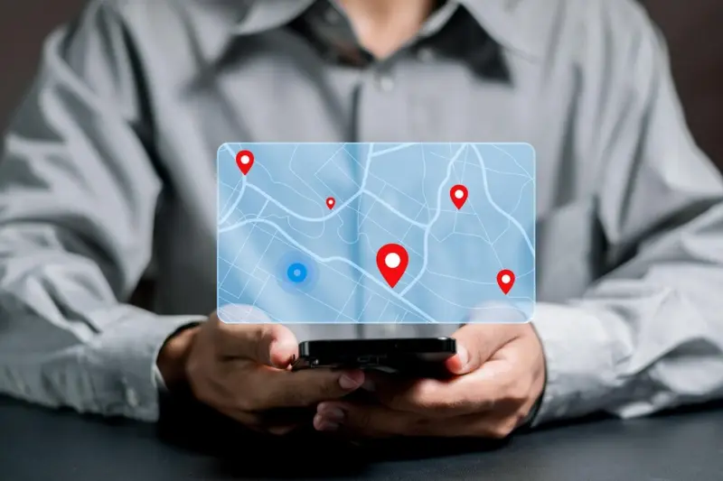Person using smartphone with digital map overlay showing location pins in business directory
